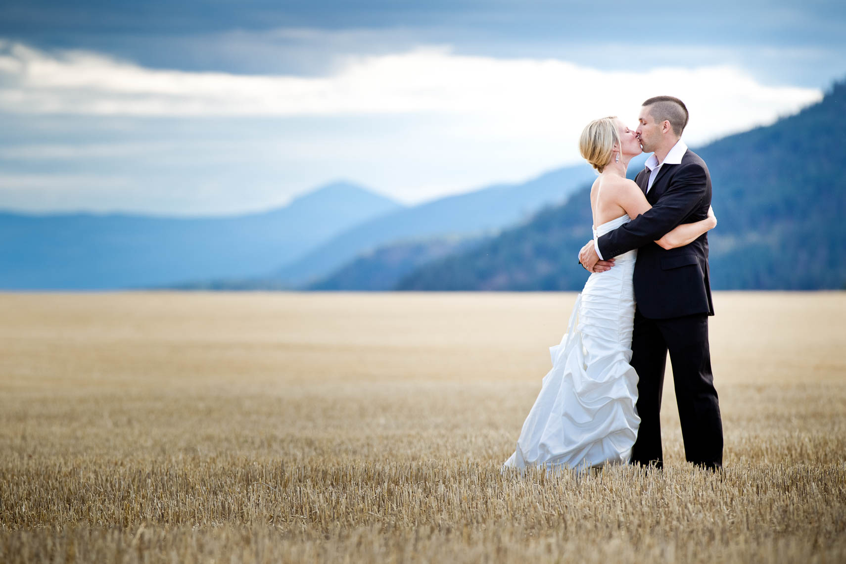 Bride and groom embrace by the mountains of Pemberton BC near whistler and Vancouver