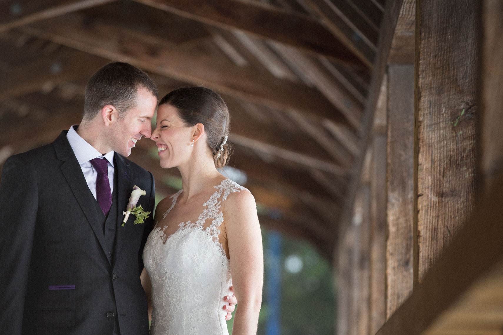 Candid moment between bride and groom on wooden covered bridge in Whistler BC
