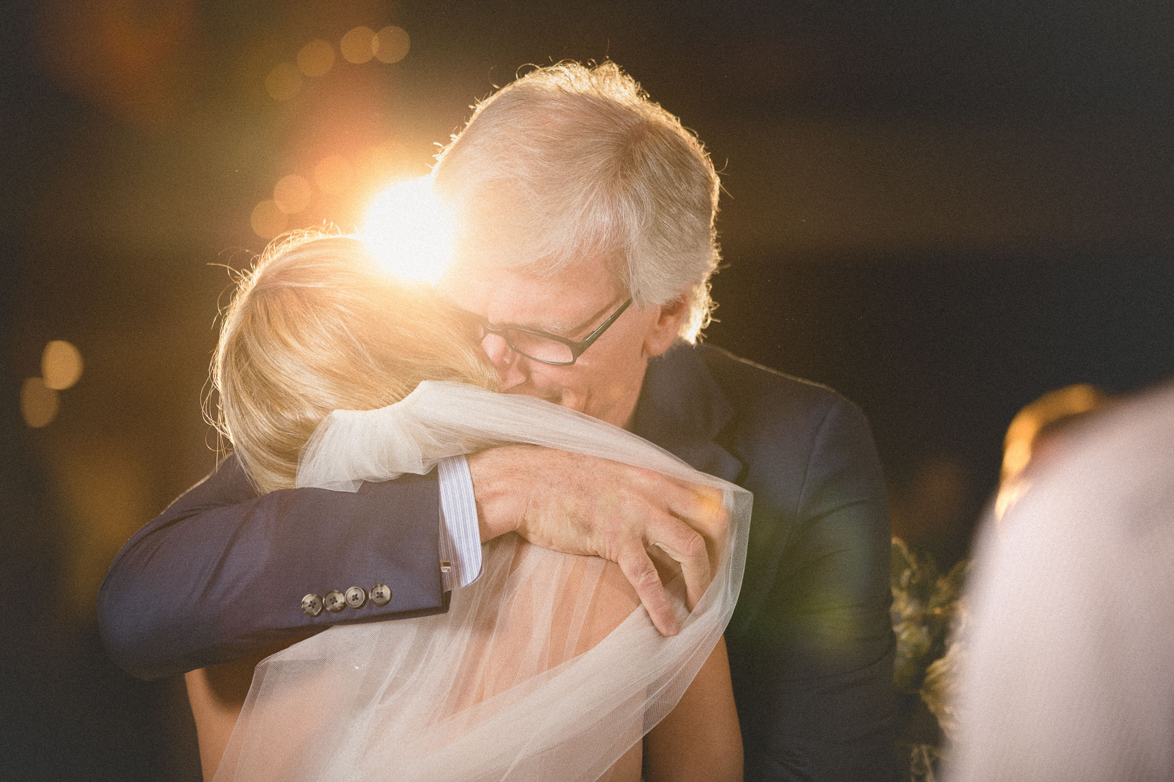Father hugs bride during ceremony at the SLCC wedding venue in Whistler