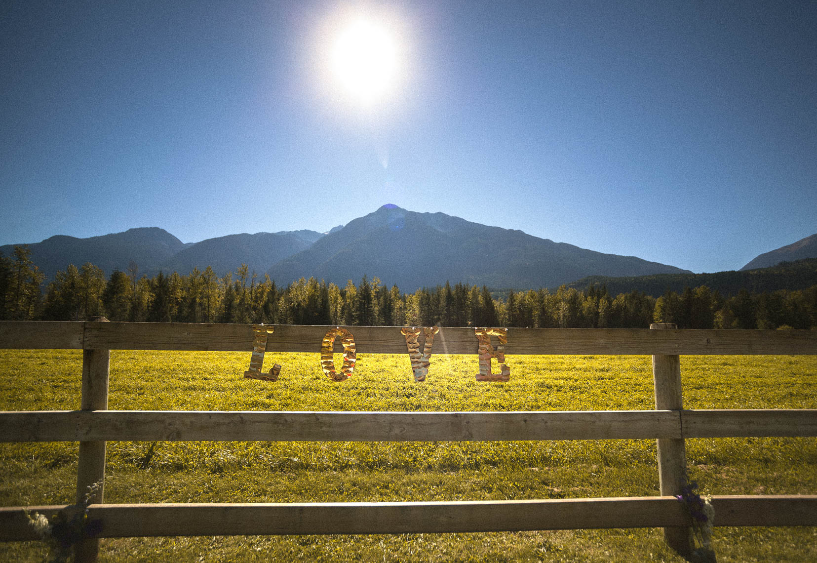 Love sign wedding decor on rustic wooden fence at whistler farm wedding.